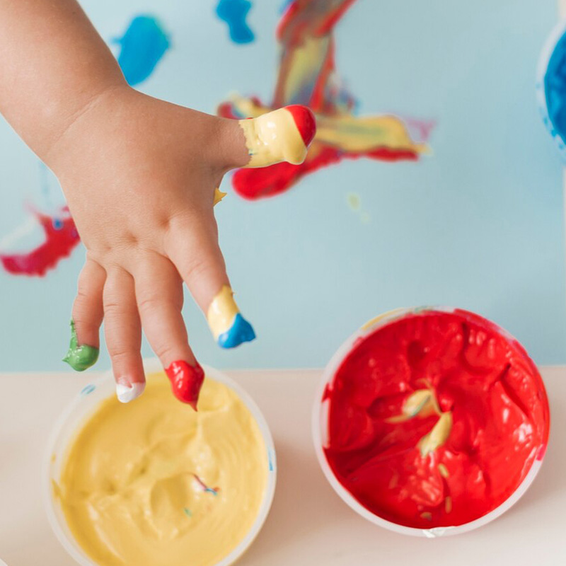 Bild mit Kinderhänden und Farbtöpfen